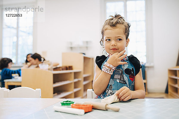 Girl playing with toys at table in child care classroom