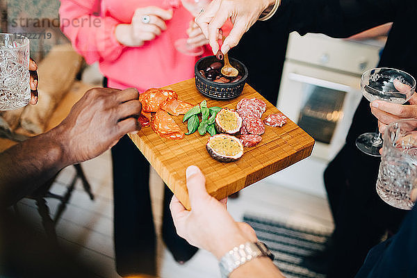 Cropped image of friends enjoying food and drinks at dinner party