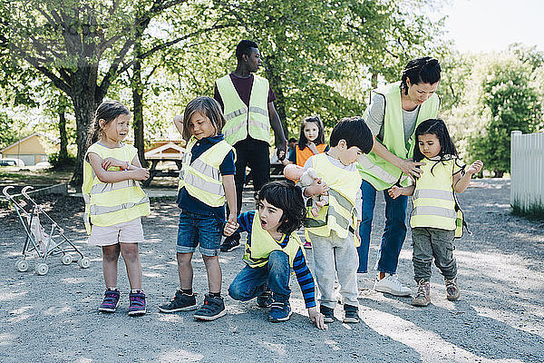 Multi-ethnic preschool students and teachers in playground