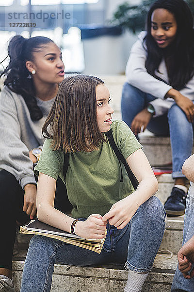 Multi-ethnic female high school students sitting on steps