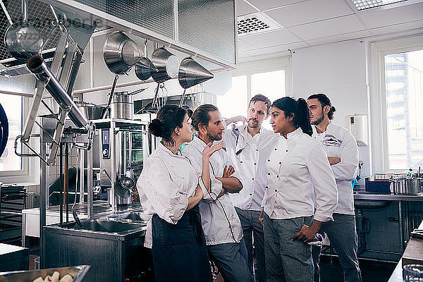 Chefs communicating in commercial kitchen
