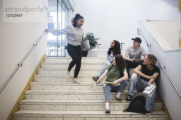 Smiling multi-ethnic students on staircase in high school