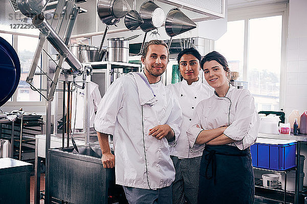 Portrait of multi-ethnic chefs standing in commercial kitchen