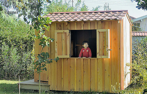 Zweijähriger kleiner Junge am Fenster der Hütte