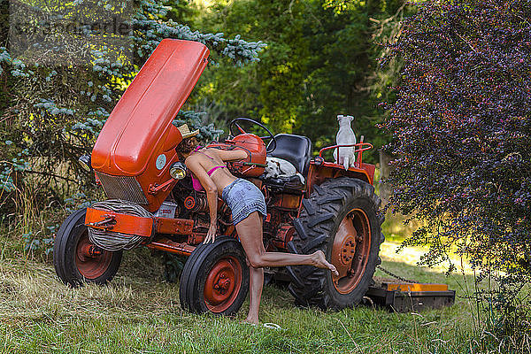 Sexy Frauen mit Blick auf den Traktormotor