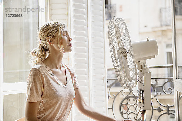 Junge Frau im Profil vor einem Ventilator.