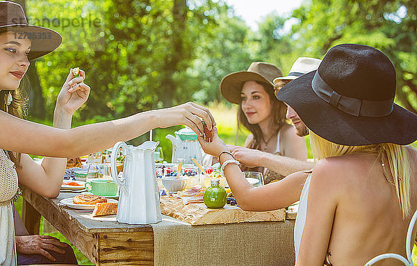 Eine Gruppe junger Leute sitzt bei einem Brunch auf dem Land. Obligatorischer Kredit: Design culinaire : food-design-studio.fr