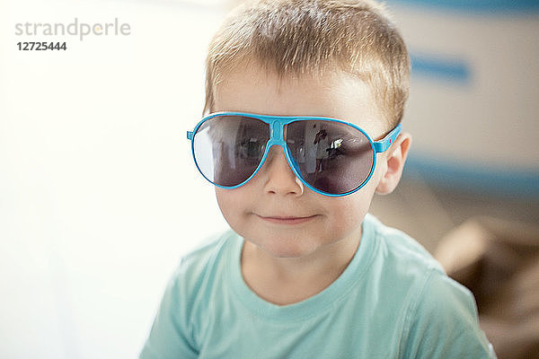 Nahaufnahme Junge mit Sonnenbrille blaue Sonne.