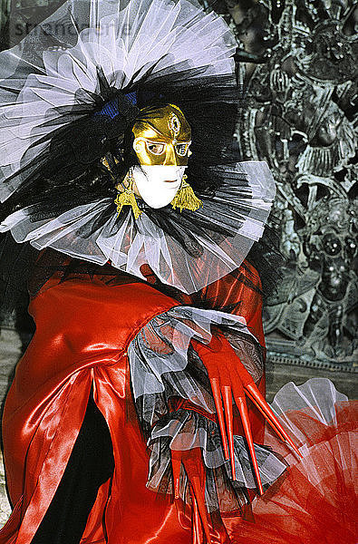 Europa  Italien  Karneval in Venedig. Roter Anzug  weiße Maske und Gold  schwarzer und weißer Tüll