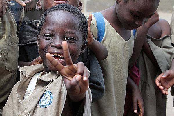 Ein togolesischer Schuljunge macht die Geste des Sieges. Grundschule Adjalle. Lome. Togo.
