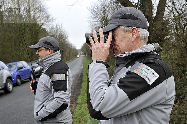Frankreich  Beamte der französischen Umweltpolitik auf Patrouille  die mit Ferngläsern eine Jagd im Departement Loire-Atlantique beobachten.