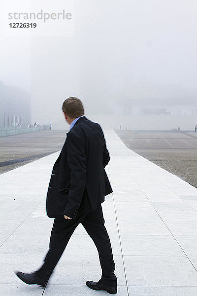 Frankreich  Paris  Defense  Geschäftsviertel  Manager vor der Grande Arche im Nebel.