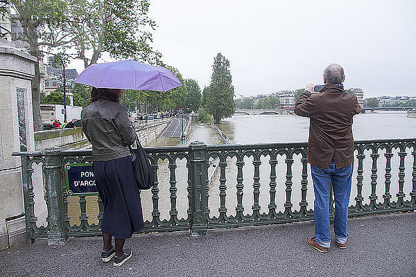 Frankreich  Paris  2 Personen auf der Arcole-Brücke beim Fotografieren des Seine-Hochwassers (2. Juni 2016)