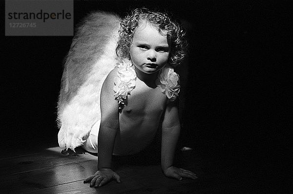 Schwarz-Weiß-Fotografie  Büste eines kleinen Mädchens mit Engelsflügeln  Innenlichteffekte