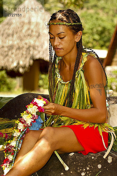 Ozeanien  Französisch-Polynesien  die Marquesas-Inseln  Insel Hiva Oa  eine junge Frau macht eine Blumenkette