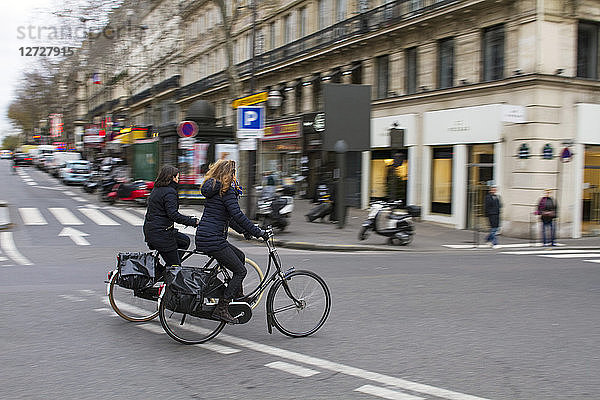 Frankreich  Paris  Montmartre Boulevard  2 Frauen auf einem Fahrrad  Dezember 2014.