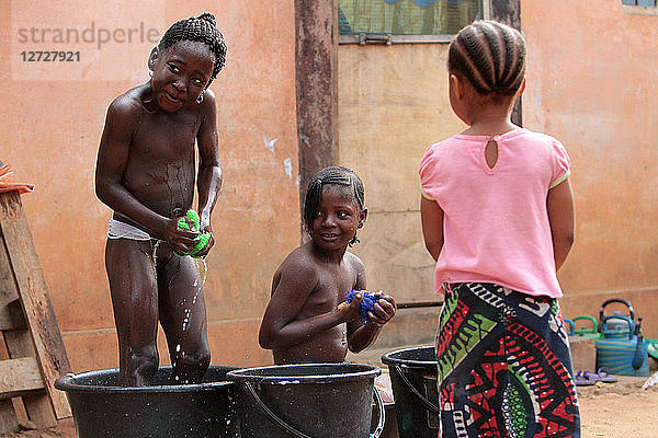 Togolesische Mädchen waschen sich in Wasserbecken. Lome. Togo.