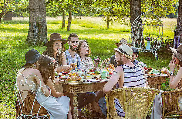Eine Gruppe junger Leute sitzt bei einem Brunch auf dem Land. Obligatorischer Kredit: Design culinaire : food-design-studio.fr