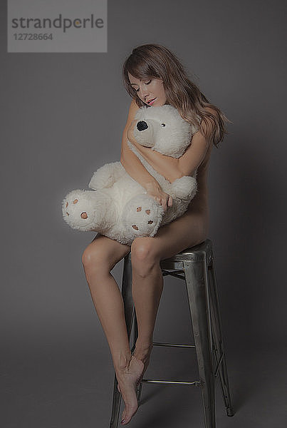 Nackte junge Frauen halten einen Teddybär