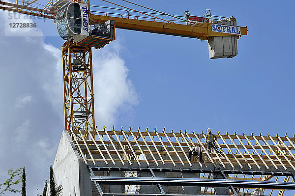 Frankreich  Stadt Nantes  Zimmerleute arbeiten auf dem Dach eines im Bau befindlichen Gebäudes.