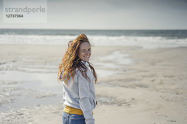 Redheaded woman relaxing on the beach  laughing