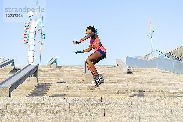 Young woman during workout on stairs  jumping