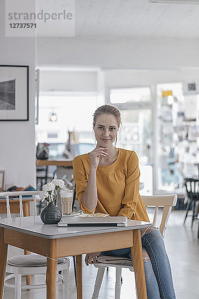 Young woman working in coworking space  taking a break