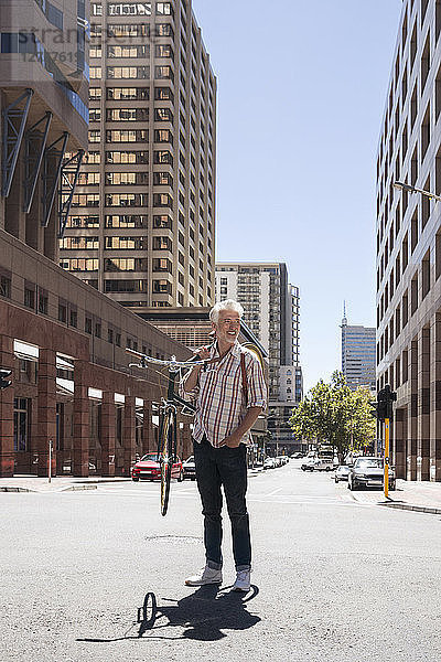 Mature man carrying his bicycle on his shoulders