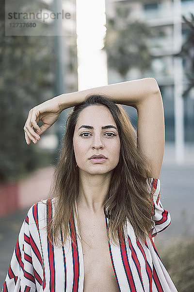 Portrait of woman wearing unbuttoned striped shirt