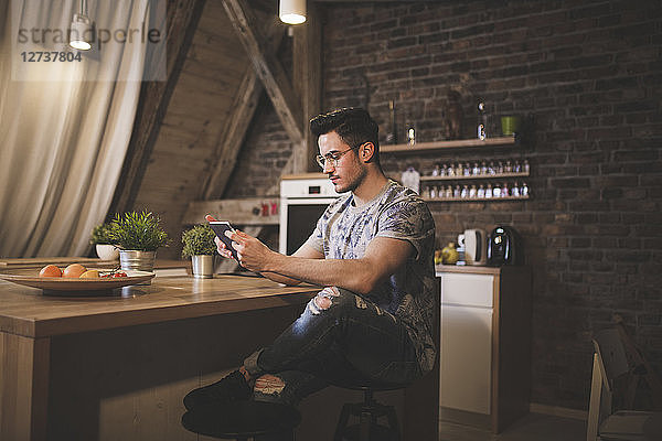 Young man using tablet in kitchen at home