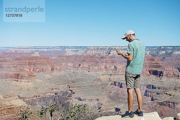 USA  Arizona  Grand Canyon National Park  Grand Canyon  man looking at smartphone