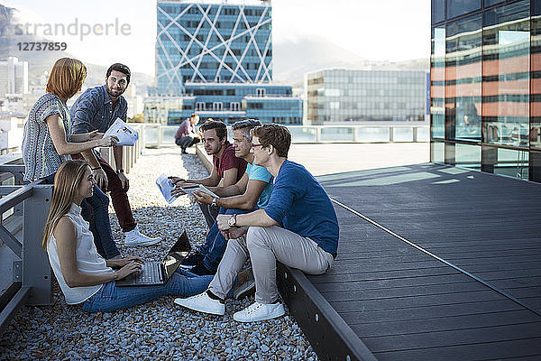 Business people having a casual meeting on a rooftop terrace