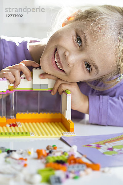 Portrait of happy little girl playing with building bricks