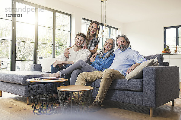 Senior couple with family sitting on couch