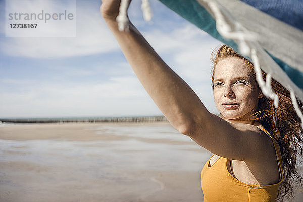 Woman at the beach  holding swaying towel