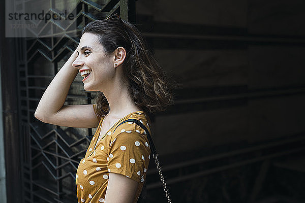 Laughing woman wearing yellow dress with polka dots
