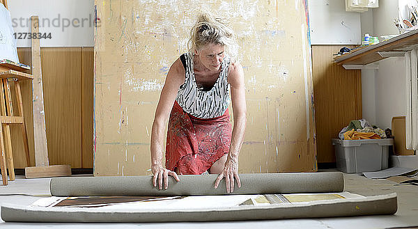 Female painter in her atelier  roll up painting