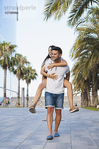 Happy couple in the city  man carrying his girlfriend piggyback