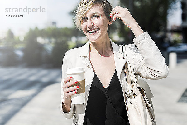 Portrait of laughing businesswoman with Coffee to go
