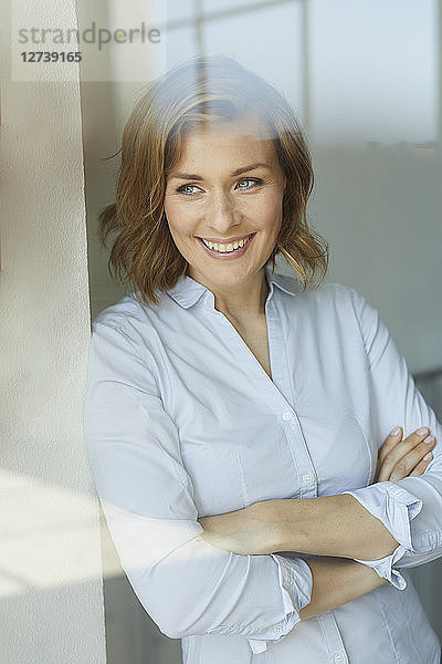 Portrait of smiling businesswoman looking out of window