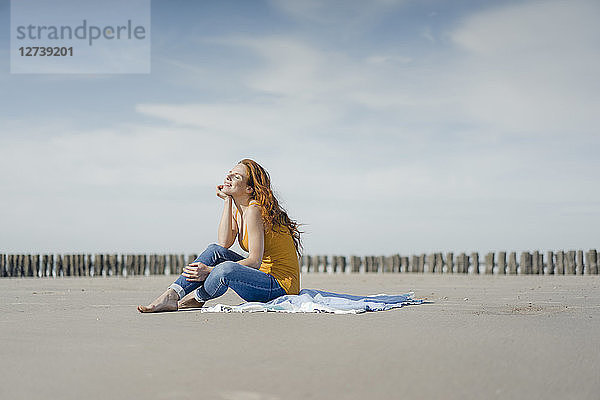 Woman sitting on the beach  enjoying the sun