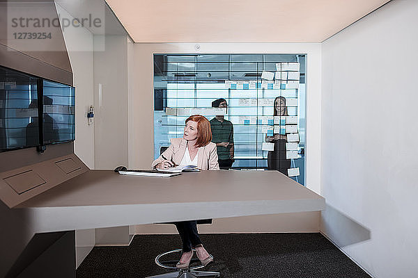 Businesswoman working in futuristic office looking at screen