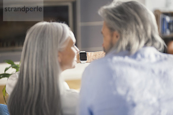 Senior couple looking at smartwatch