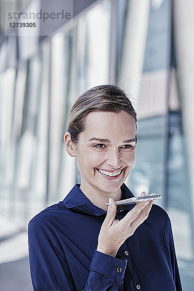 Portrait of smiling businesswoman using cell phone