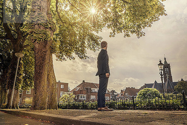 Netherlands  Venlo  businessman standing on pavement looking around
