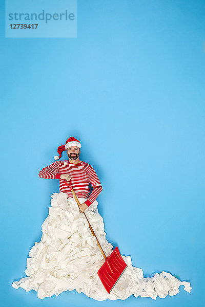 Man with Santa hat shoveling snow