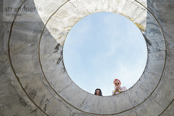 Two alternative friends looking through hole