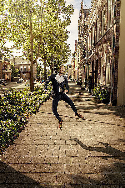 Netherlands  Venlo  happy businessman jumping on pavement