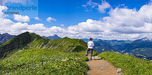 Germany  Allgaeu Alps  Hiker standing on path looking at panoramic road from Fellhorn to Sollereck mountain