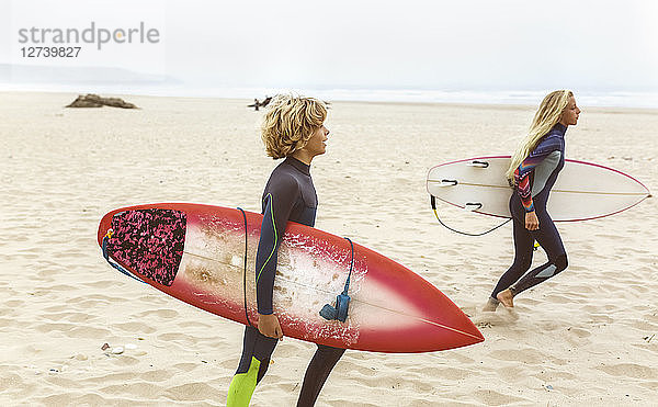 Spain  Aviles  two young surfers on the beach